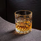 Soleil Whiskyglas mit Whisky gefüllt steht an einer Kante und schimmert im Licht